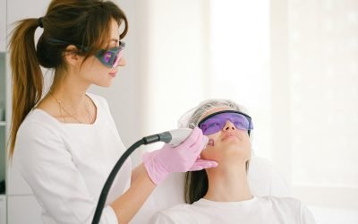 Une cosmétologue effectuant un traitement au laser sur une femme dans une clinique.