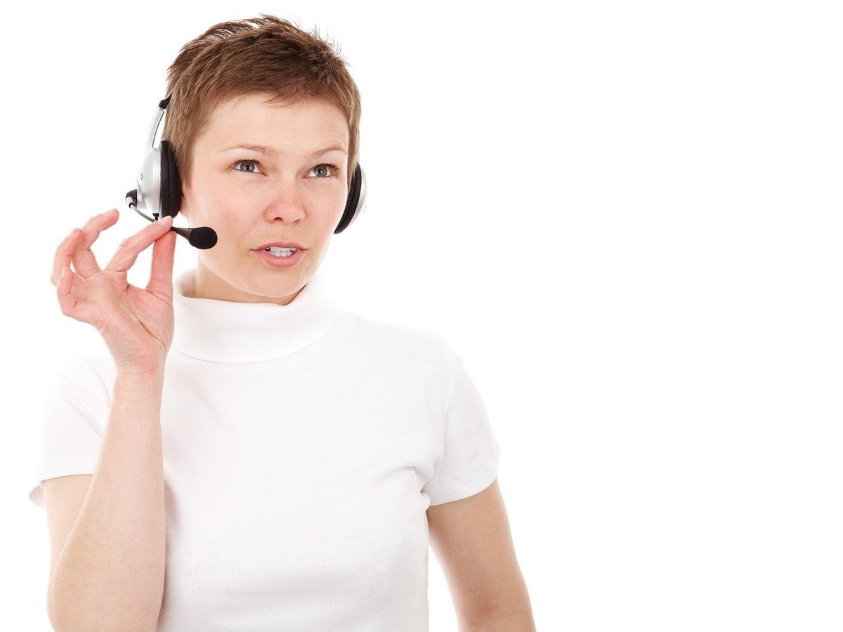 Femme en t-shirt blanc portant un casque téléphonique avec microphone Femme en t-shirt blanc portant un casque téléphonique avec microphone