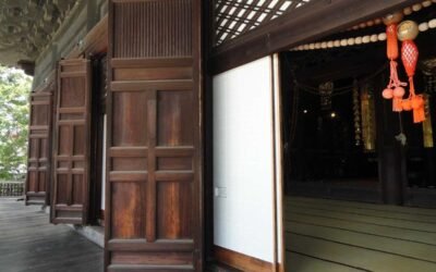 Portes en bois ouvertes sur un sol tatami, décorations rouges suspendues