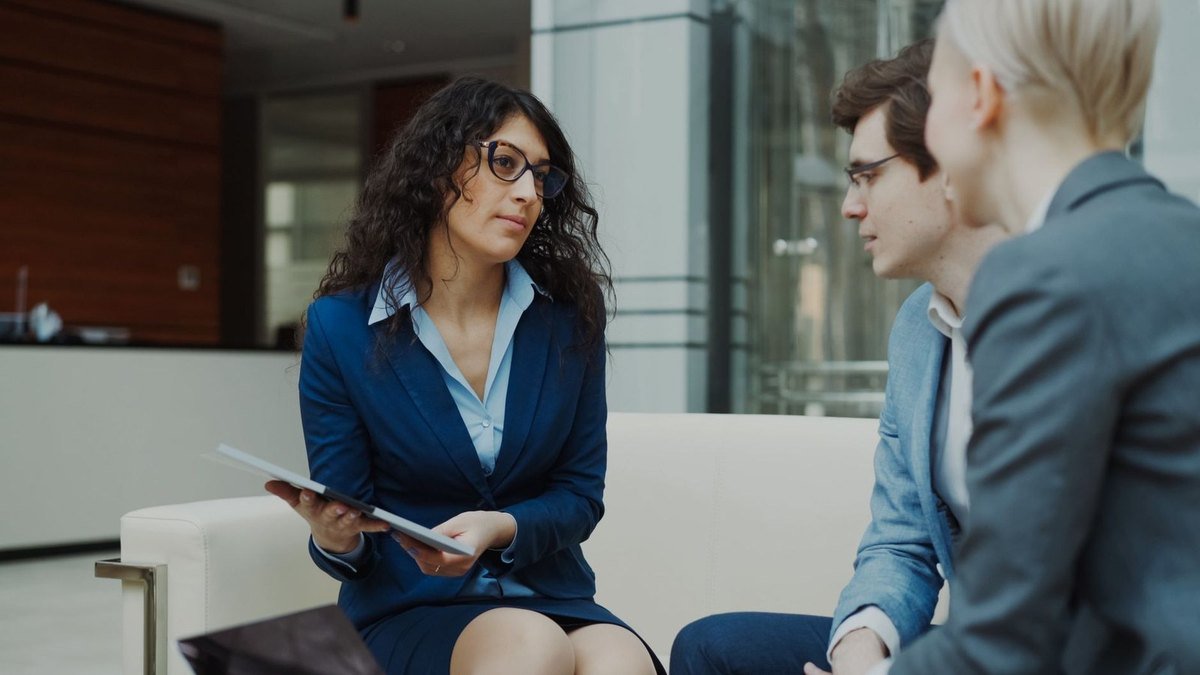 Professionnels discutant autour d'un document dans un environnement de bureau