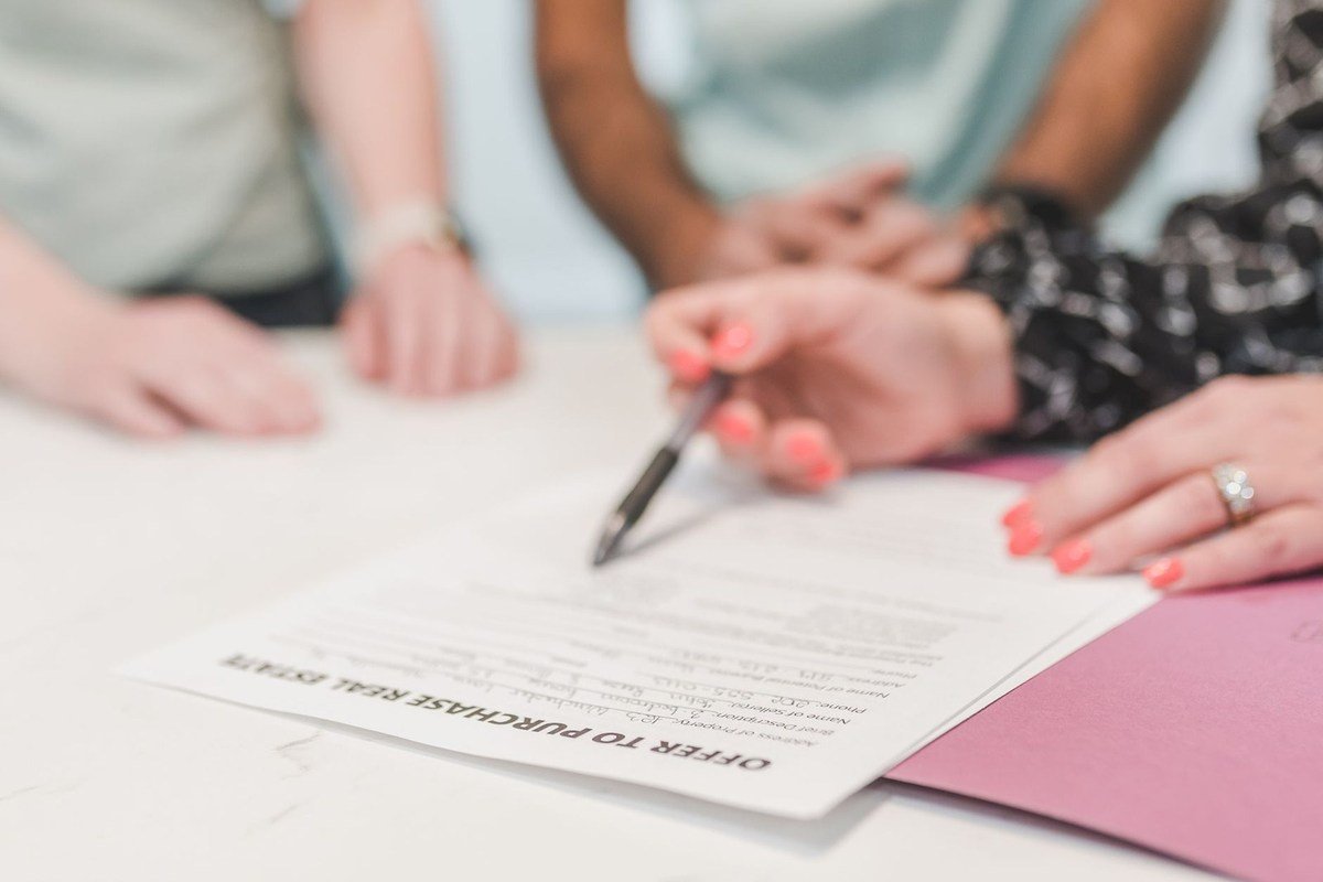 Mains et document sur une table, signature en cours