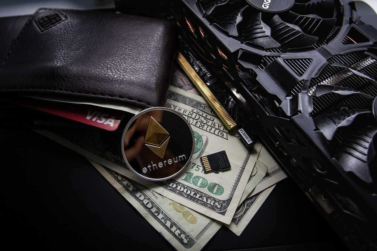 Portefeuille avec carte de crédit, jeton Ethereum, fan de PC, microprocesseur et billets de 100 dollars