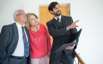 Homme en costume pointant un document, deux personnes observant, dans un bureau